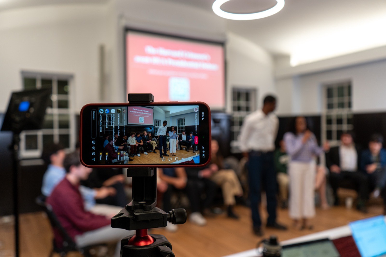 A phone on a tripod livestreaming a Harvard Undergraduate Association event